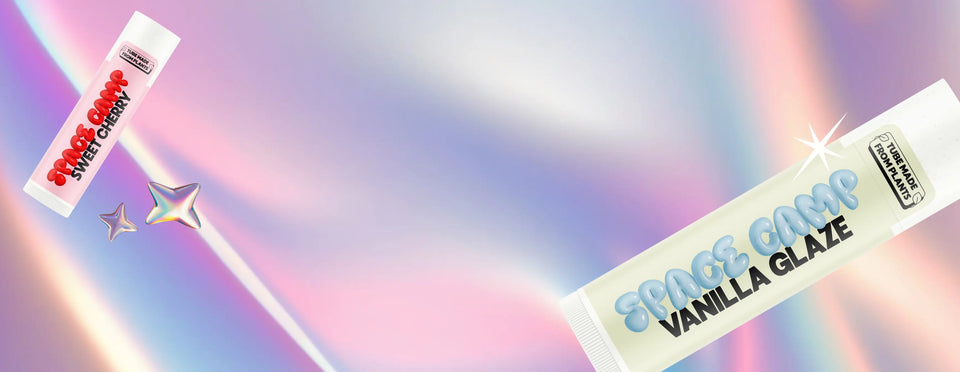 Space Camp Sweet Cherry and Vanilla Glaze lip balms displayed against a pastel iridescent background with star accents