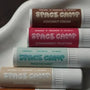 Watermelon lip balm being applied by woman using Space Camp juicy watermelon for soft hydration.