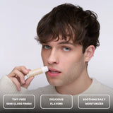 A person applying Space Camp vanilla lip balm with feature callouts for tint-free finish, flavor, and daily lip moisturizer.