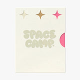 A Space Camp branded card with sparkle graphics and a pink lip balm tube peeking from behind.