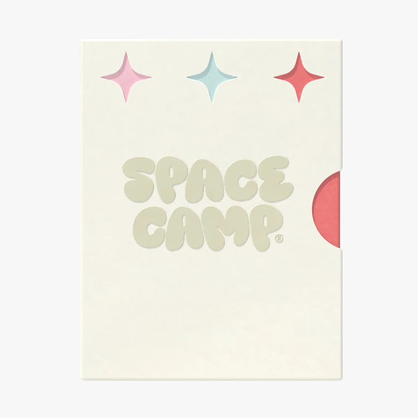 A Space Camp branded card with sparkle graphics and a red lip balm tube peeking from behind.