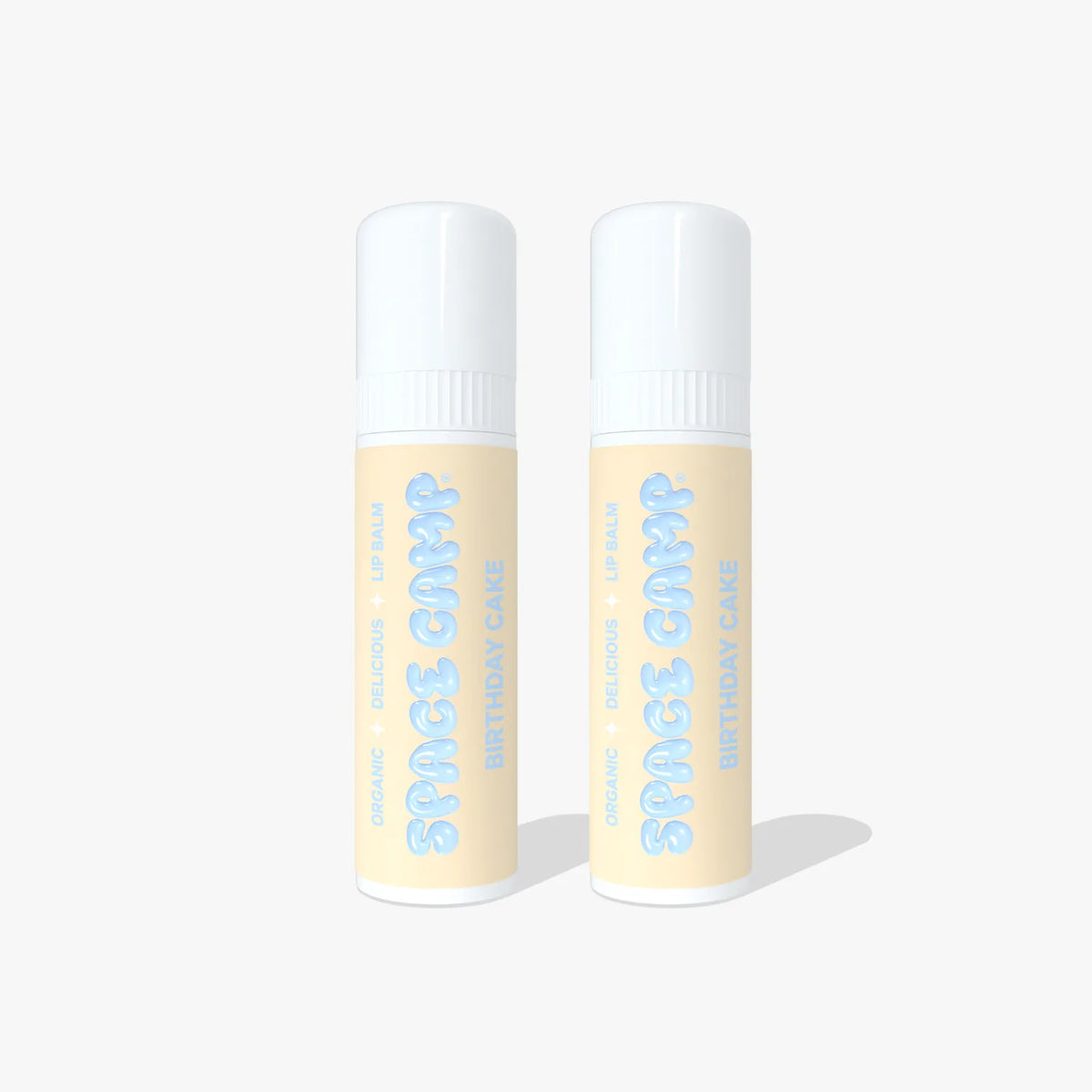 Two Space Camp Birthday Cake lip balm tubes with light yellow labels and white caps standing side by side on a white background.