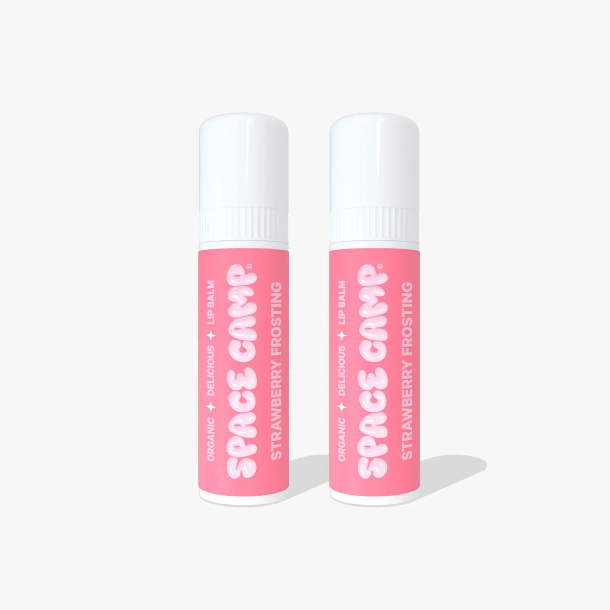 Two Space Camp Strawberry Frosting lip balm tubes with pink labels standing side by side on a white background.