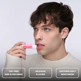 Young man applying Space Camp Wild Cherry Lip Balm, highlighting its tint-free semi-gloss finish and soothing daily moisturizer benefits.