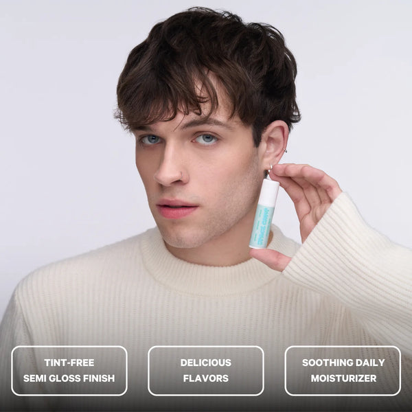 Young man holding Space Camp Frosted Mint Lip Balm, highlighting its tint-free semi-gloss finish and soothing daily moisturizer benefits.